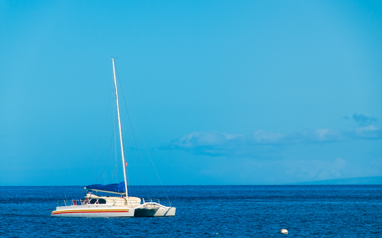 Catamaran on a sunny blue day moored in the Pacific Ocean off the island of Maui, Hawaii, USA